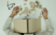 Exhausted man with head on desk surrounded by scattered stationery, illustrating ad fatigue.