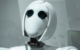 White humanoid robot with expressive eyes symbolizing the role of AI in creative industries.